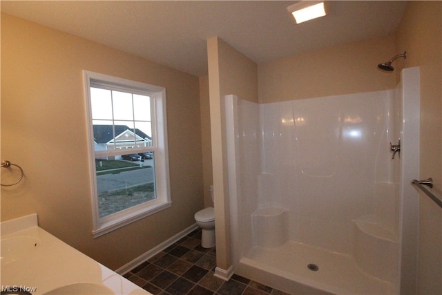 bathroom featuring tile flooring, a shower, double vanity, and toilet