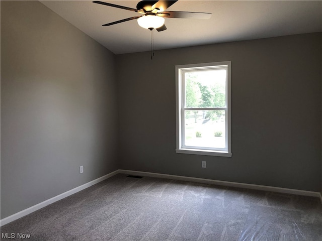 spare room with dark colored carpet, lofted ceiling, and ceiling fan