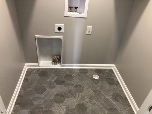 laundry room featuring hookup for an electric dryer, dark tile flooring, and hookup for a washing machine