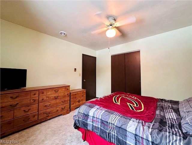 carpeted bedroom featuring ceiling fan and a closet