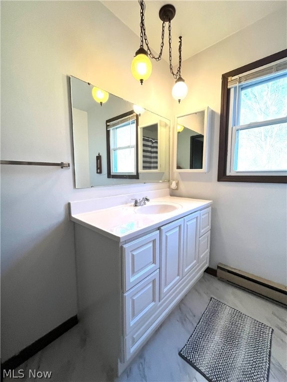 bathroom featuring vanity, a healthy amount of sunlight, and a baseboard radiator