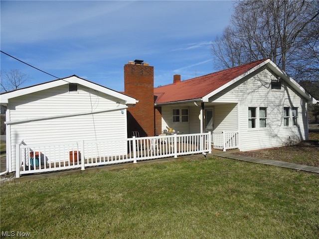 rear view of house featuring a lawn