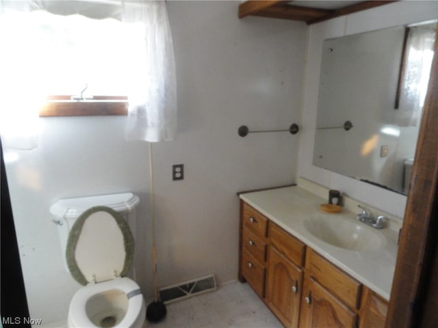 bathroom featuring tile floors, toilet, and vanity with extensive cabinet space