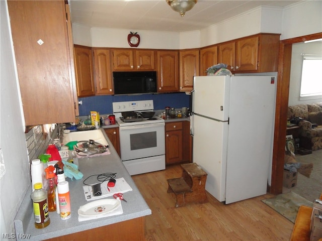 kitchen with white appliances, sink, light hardwood / wood-style floors, and tasteful backsplash