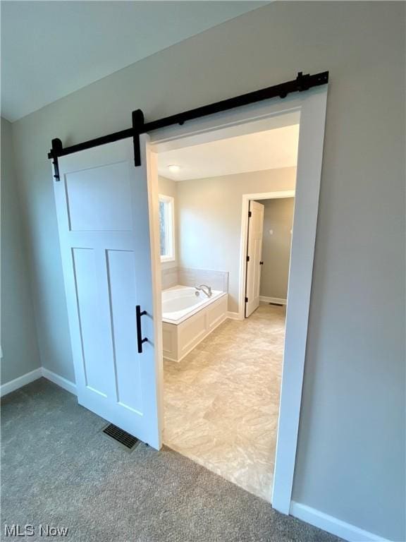 bathroom featuring visible vents, a bath, and baseboards