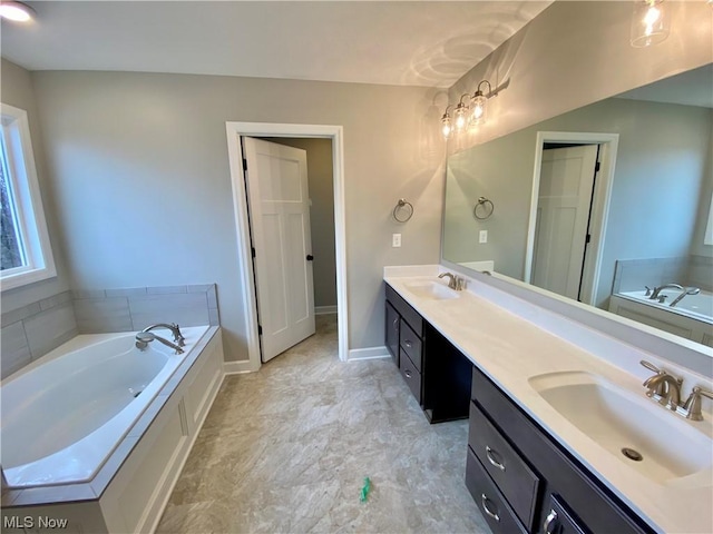 bathroom featuring double vanity, a sink, baseboards, and a bath