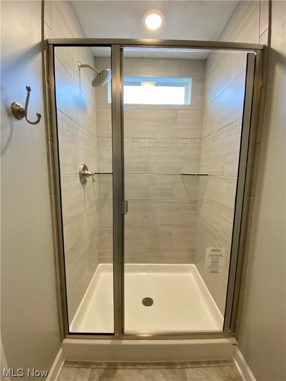 full bathroom featuring a stall shower and baseboards