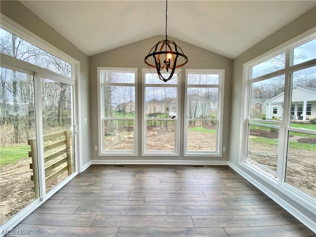 unfurnished sunroom with lofted ceiling, a wealth of natural light, and an inviting chandelier