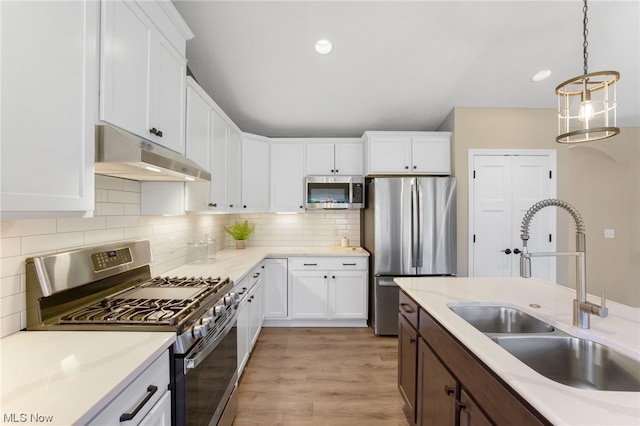 kitchen with light hardwood / wood-style floors, white cabinetry, sink, and appliances with stainless steel finishes