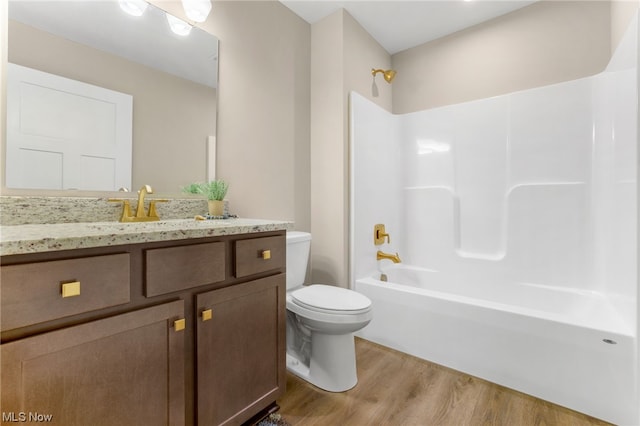 full bathroom with bathtub / shower combination, wood-type flooring, vanity, and toilet