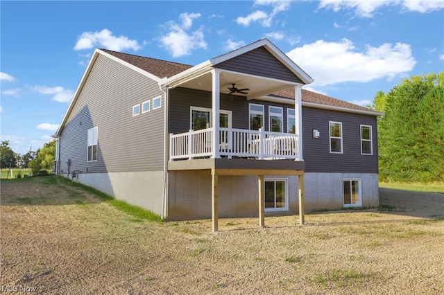 back of house featuring a lawn, ceiling fan, and a wooden deck