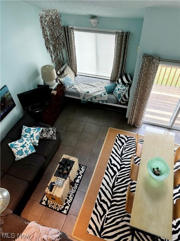 living room featuring a textured ceiling and tile patterned floors