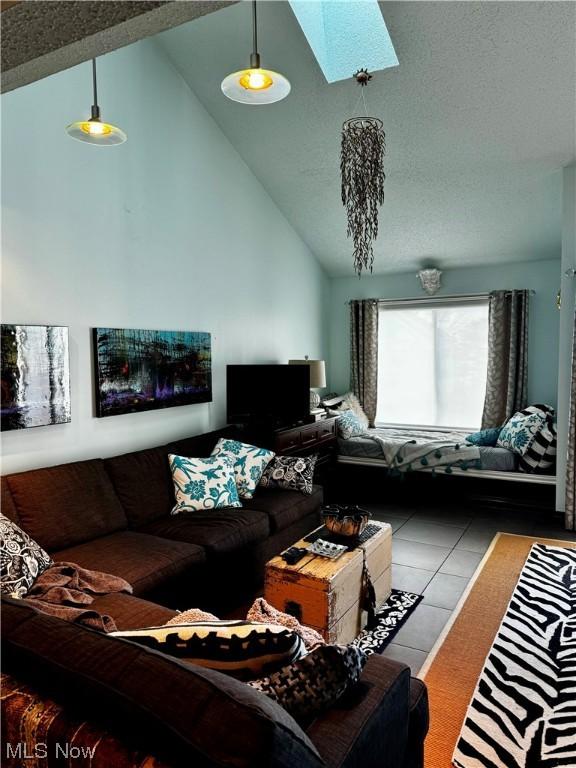 living area with a skylight and high vaulted ceiling