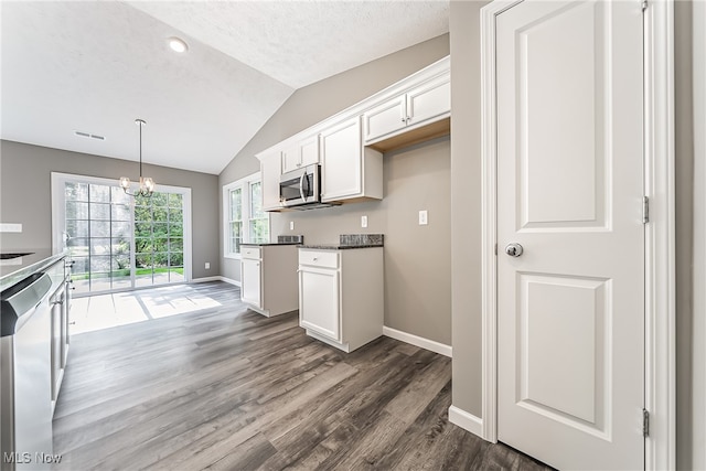 kitchen featuring dark wood-type flooring, stainless steel appliances, vaulted ceiling, and white cabinets