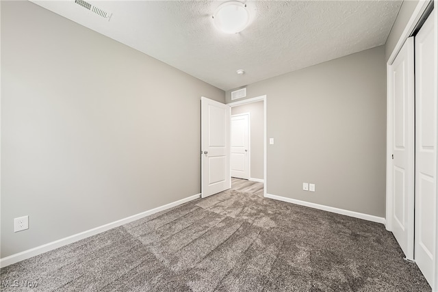 unfurnished bedroom with a closet, carpet flooring, and a textured ceiling