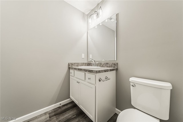 bathroom with vanity, toilet, and hardwood / wood-style flooring