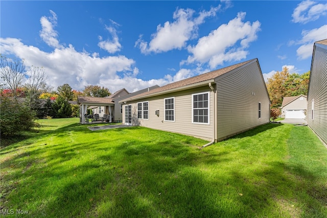 rear view of property featuring a yard and a patio area