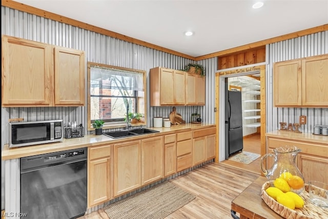 kitchen featuring light brown cabinetry, black appliances, sink, and light wood-type flooring