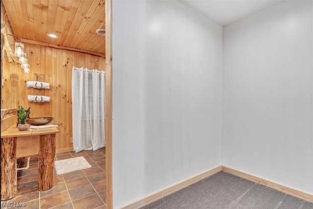 bathroom with tile floors and wood walls