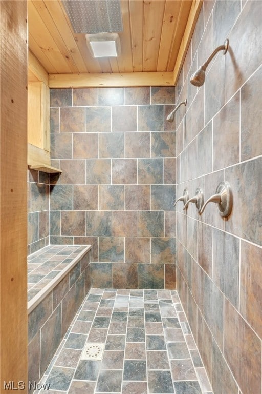 bathroom with tiled shower and wood ceiling