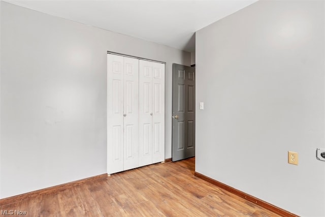 unfurnished bedroom with a closet and light hardwood / wood-style flooring