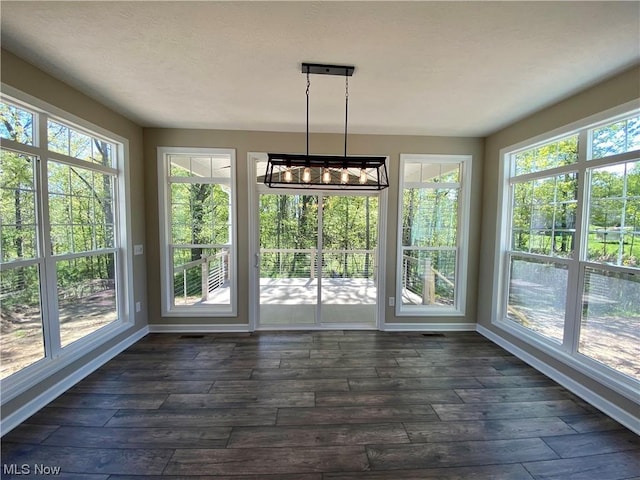 2439 Ledgestone Dr NW, Uniontown, OH 44685 - unfurnished sunroom with plenty of natural light, baseboards, and hardwood / wood-style floors