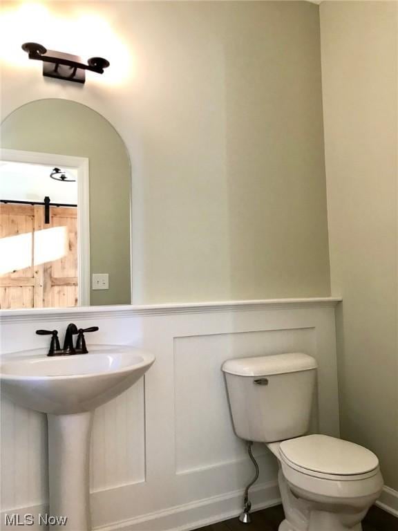 bathroom featuring baseboards and toilet