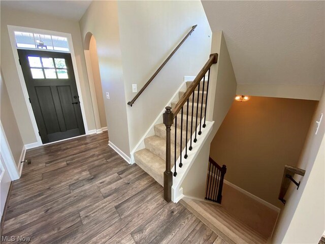 2439 Ledgestone Dr NW, Uniontown, OH 44685 - foyer with arched walkways, wood finished floors, baseboards, and stairway