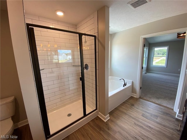 full bath with visible vents, a shower stall, toilet, and wood finished floors