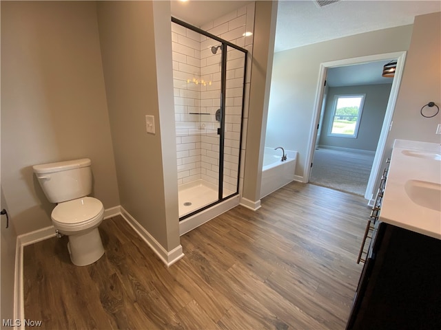 full bathroom featuring vanity, separate shower and tub, hardwood / wood-style floors, and toilet