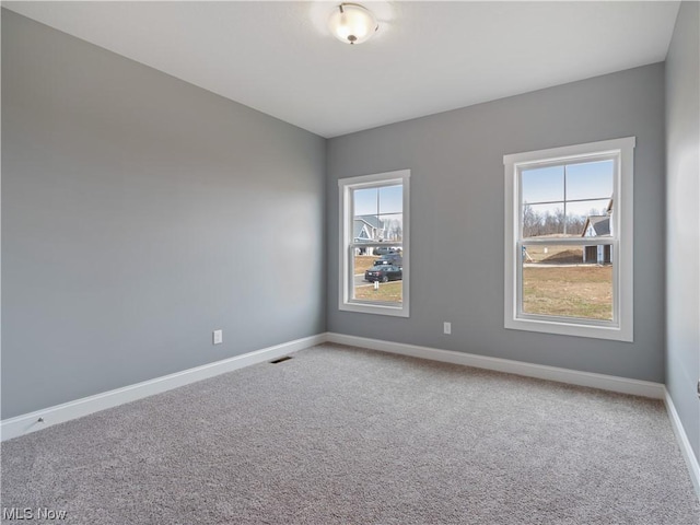 unfurnished room with carpet floors and baseboards