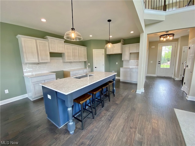 kitchen with sink, a center island with sink, and white cabinets