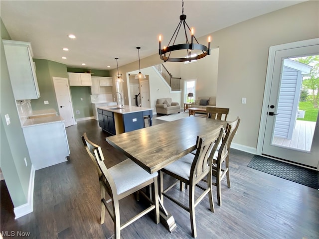 dining room featuring plenty of natural light, dark hardwood / wood-style flooring, a chandelier, and sink