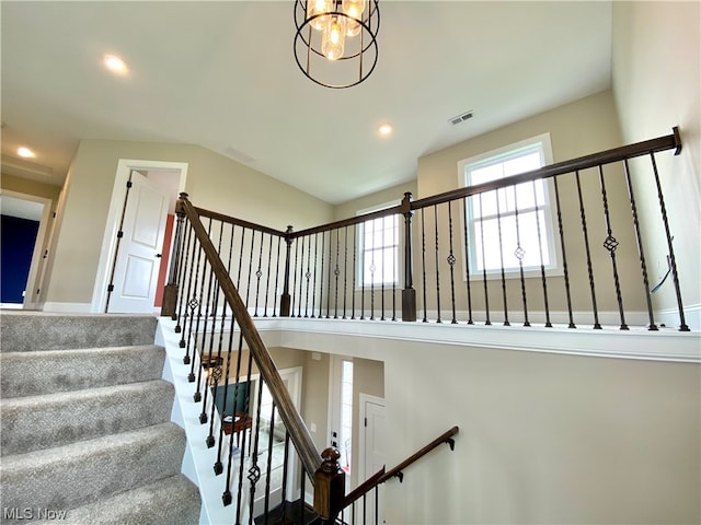 staircase with a high ceiling and an inviting chandelier