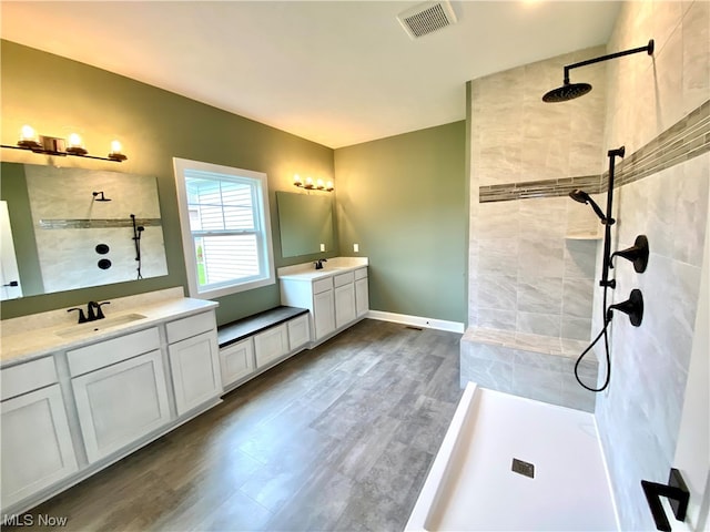 bathroom featuring vanity, hardwood / wood-style flooring, and a tile shower