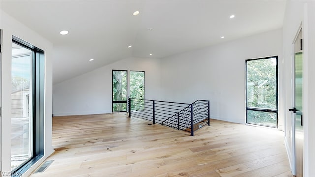 interior space featuring lofted ceiling and light hardwood / wood-style flooring