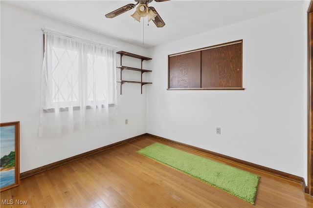 empty room featuring ceiling fan, golf simulator, and light wood-type flooring