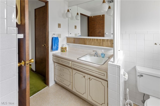 bathroom with tile walls, toilet, and vanity