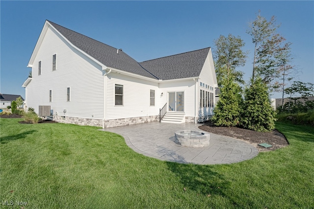 rear view of house with a fire pit, a lawn, cooling unit, and a patio