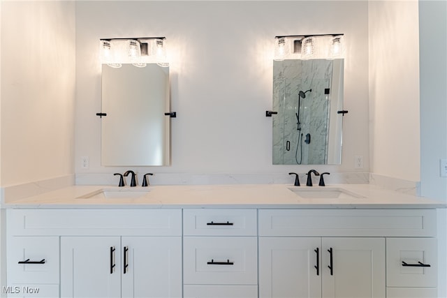 bathroom featuring a shower with door and vanity