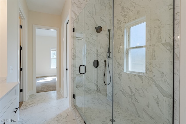 bathroom featuring a shower with door and vanity