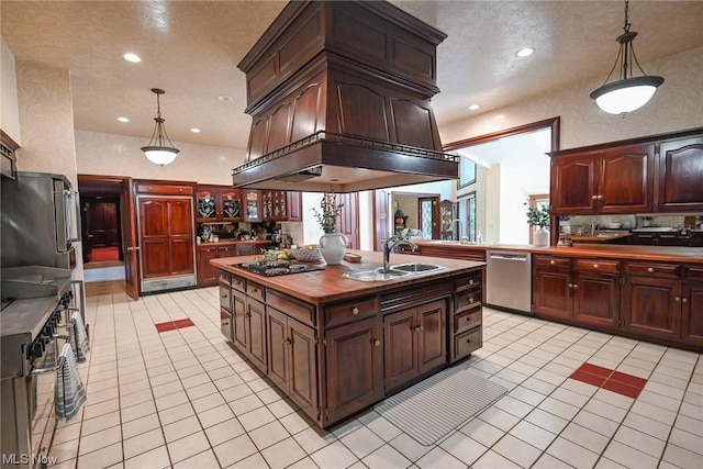 kitchen featuring sink, light tile patterned floors, stainless steel appliances, and decorative light fixtures