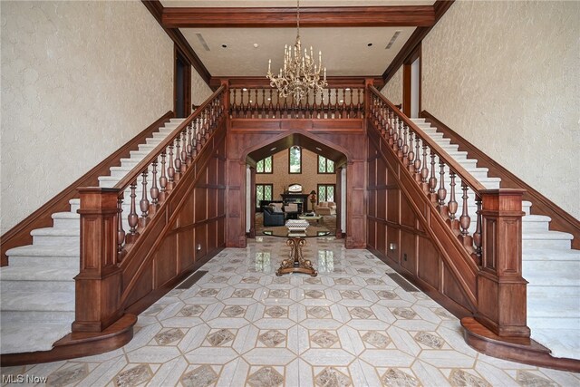 foyer entrance with a chandelier and beam ceiling