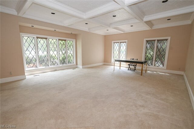 carpeted spare room with beam ceiling, crown molding, and coffered ceiling