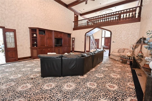 living room featuring beamed ceiling, a high ceiling, ceiling fan, and carpet