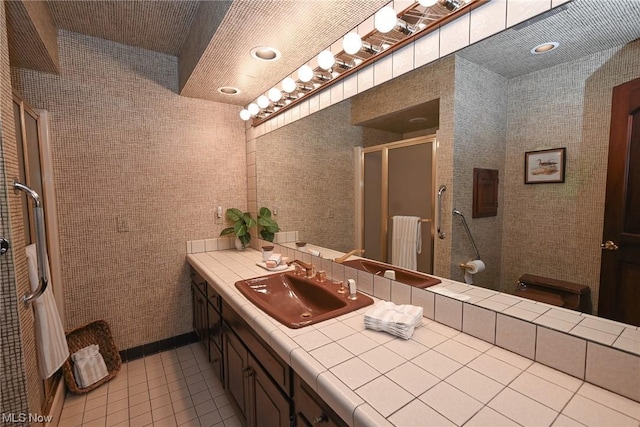 bathroom with tile patterned flooring, vanity, and walk in shower