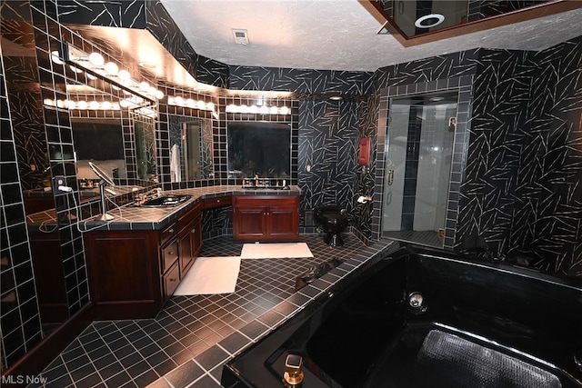 bathroom with tile patterned flooring, shower with separate bathtub, vanity, and a textured ceiling