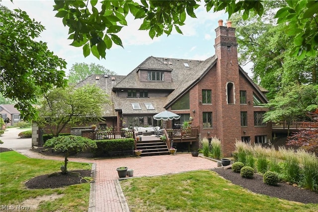 rear view of property with an outdoor living space, a yard, and a deck