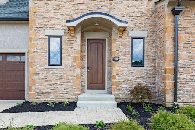 doorway to property with a garage