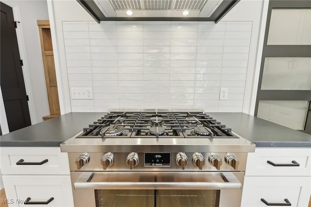 kitchen featuring decorative backsplash, stainless steel gas range oven, range hood, and white cabinetry